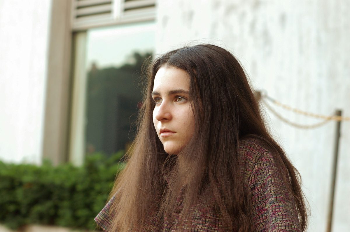 Mujer joven con el pelo largo mirando a lo lejos