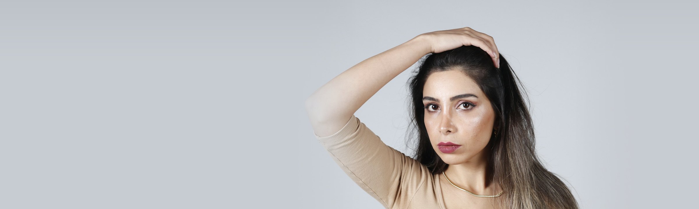 Mujer joven con el pelo largo y la mano sobre la cabeza