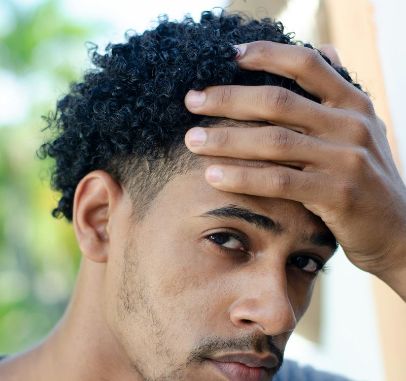 Hombre tocándose el nacimiento del pelo
