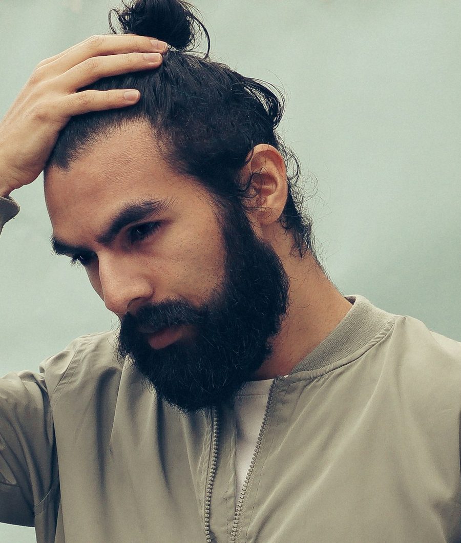 Hombre con barba tocándose el pelo