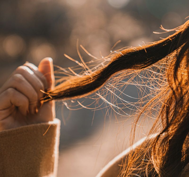 Mujer sujetando un mechón de pelo fino y quebradizo